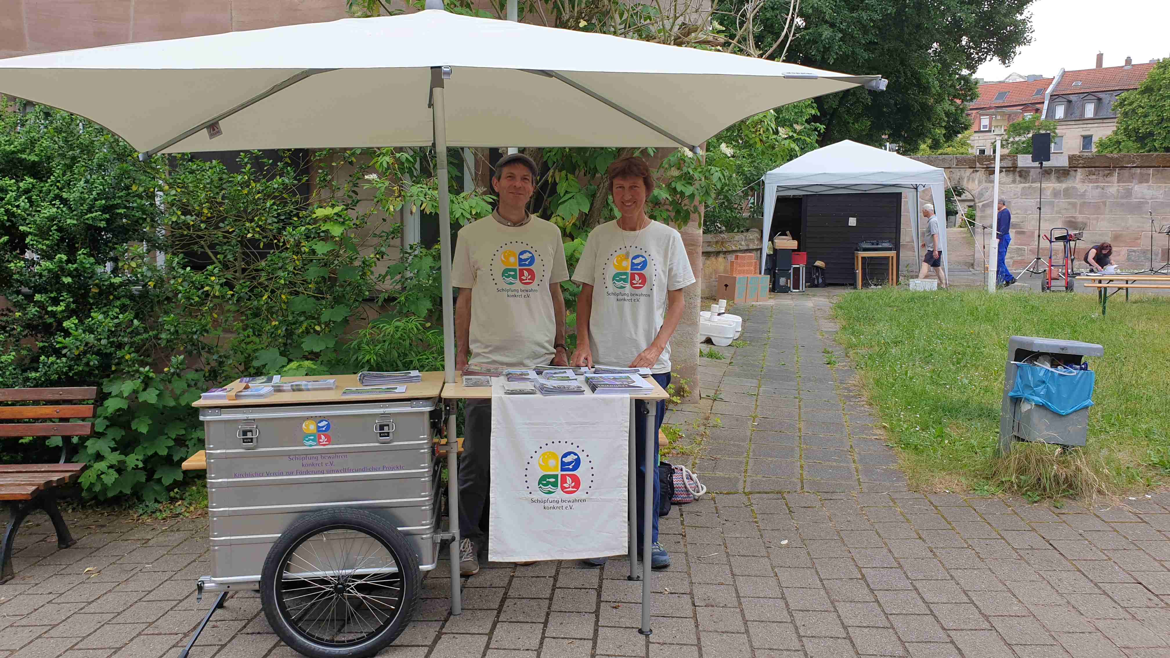 Man sieht zwei Personen am Anhängerstand des Vereins.