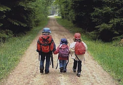 Drei Kinder laufen einen Waldweg entlang